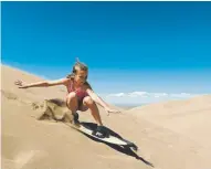  ??  ?? Clara Abel, 8, surfs down a dune on June 20.