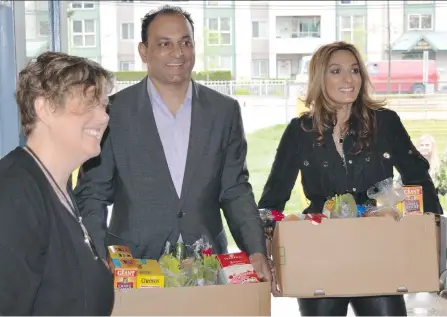  ??  ?? Vice-principal Diana Ellis opens the door for David Sidoo and his wife, Manjy, who have pledged to support a pilot program that provides groceries to some children at Surrey’s Old Yale Road elementary school whose families are often without enough food...