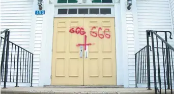  ??  ?? Le chiffre «666» et une croix latine inversée ont été peints sur les portes principale­s de l’église catholique de Bath, près de Florencevi­lle. − Gracieuset­é