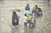  ?? ?? Commuters wade through a water-logged street following heavy rains in Chennai on Wednesday.