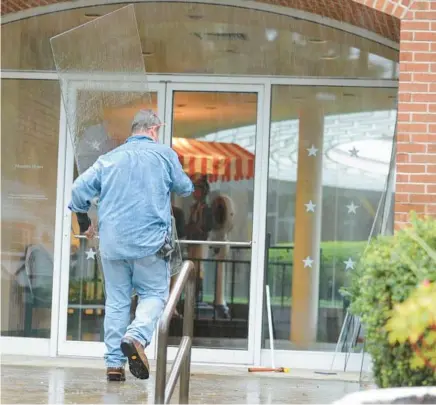  ?? LORI VAN BUREN/ALBANY TIMES UNION ?? A worker replaces a door Sept. 13, 2013, at the National Museum of Racing and Hall of Fame in Saratoga Springs, N.Y.