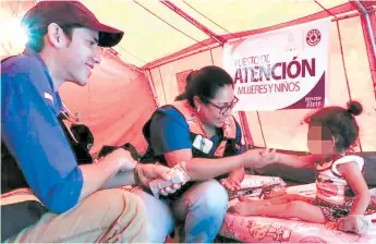  ?? FOTO: EL HERALDO ?? Miembros de Copeco brindan asistencia a los migrantes hondureños en la ruta hacia a México.