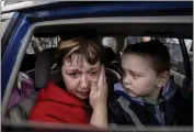  ?? EVGENIY MALOLETKA — THE ASSOCIATED PRESS ?? Natalia Pototska, 43, cries as her grandson Matviy looks on in a car at a center for displaced people in Zaporizhzh­ia, Ukraine, on Monday.