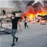  ?? NABIL AL-JURANI, AP ?? Protesters demanding jobs and better public services try to storm the governor's building in Basra, Iraq , last week.