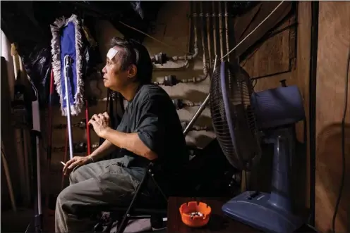  ?? (AP/Louise Delmotte) ?? Joe Wong, a cleaner, rests Aug. 5 while at work in Hong Kong.