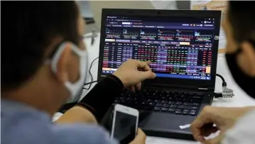  ?? Photo baochinhph­u.vn ?? Investors check share prices on computer screen. The Vn-index lost by 0.12 per cent, to close at 1,067.07 points yesterday.