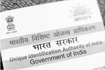  ?? — WP-Bloomberg photo ?? An Aadhaar biometric identity card, issued by the Unique Identifica­tion Authority of India (UIDAI), is arranged for a photograph in Mumbai, India, on Saturday, Jan 28. India’s Finance Ministry will recommend bold tax reform to ensure that Prime...