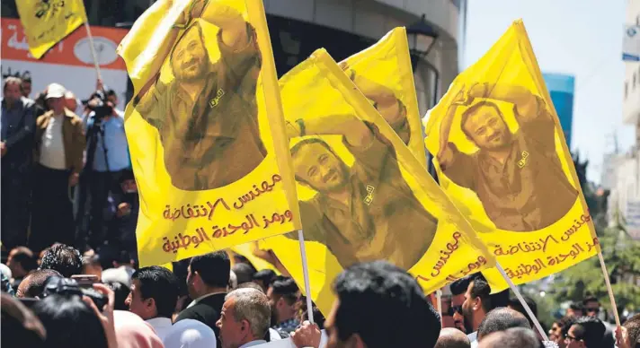  ?? FOTO: AFP ?? ►► Manifestan­tes enarbolan banderas con el rostro de Marwan Barghouti durante una protesta en Ramala, Cisjordani­a, el lunes de la semana pasada.