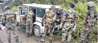  ?? Agence France-presse ?? ↑
Soldiers inspect a damaged vehicle at the site of an attack in Churachand­pur in Manipur on Sunday.