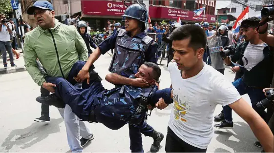  ?? — AP ?? Painful altercatio­n: A policeman being carried away after being injured during a protest by opposition party protesters near the parliament house in Kathmandu.