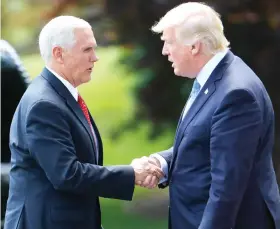  ??  ?? President Donald Trump shakes hands with Vice President Mike Pence before walking across the South Lawn of the White House in Washington on Friday. (AP)