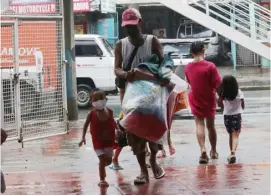  ?? PHOTOGRAPH BY ANALY LABOR FOR THE DAILY TRIBUNE @tribunephl_ana ?? WITH some of their belongings, a father leads his son to an evacuation center in a safer part of Marikina City after water rose in some parts of the Marikina River.