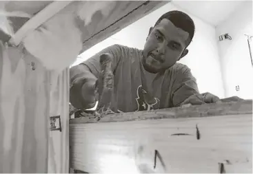  ?? Lisa Falkenberg / Houston Chronicle ?? Roberto Vidales, an undocument­ed carpenter who came to the United States with his parents when he was a baby, works with a demolition crew to remove molding wood from a flooded home in Meyerland.