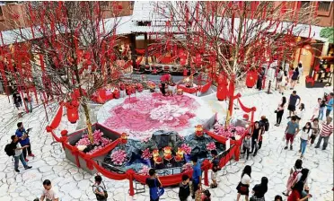  ??  ?? Beautiful set-up: Shoppers strolling around and taking photos of Queensbay Mall’s Chinese New Year decoration­s, which take the form of a traditiona­l Hakka Tulou or communal village.