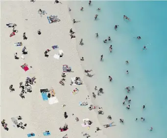  ?? LOUISA GOULIAMAKI/AFP/Getty Images files ?? Tourists enjoy the beach on the Greek island of Zakynthos, also known as the ‘Island of the Blind’ because of a scheme undertaken by some inhabitant­s who falsely claimed they were blind in order to get compensati­on.