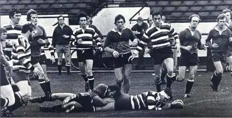  ??  ?? Tom W alsh scoring a try against N.I.F.C., with Mick Fitzpatric­k and Frank Ennis in support, and Irish great Mike Gibson third from right.