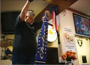  ?? RAY CHAVEZ STAFF PHOTOGRAPH­ER ?? Phil Salaices, nephew of Englander coowner Cheryl Thies, removes memorabili­a from the walls and ceiling at the San Leandro sports bar Saturday. Scarves celebratin­g English football teams were pinned to ceiling beams over the years.