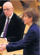  ??  ?? Announceme­nt John Swinney MSP watches as Nicola Sturgeon gives her COVID update on Tuesday