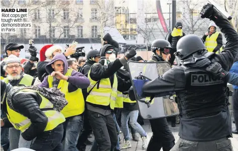  ??  ?? HARD LINE Riot cops get tough with demonstrat­ors in Paris