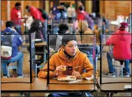  ?? (AP/Charlie Riedel) ?? Freshman Hugo Bautista eats lunch separated from classmates by plastic dividers at Wyandotte County High School in Kansas City, Kan., on March 31, the school’s first day of in-person learning.