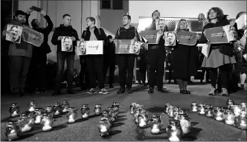  ??  ?? File photo shows people holding placards reading “Who are Gandzyuk’s killers” stand behind candles in front of the Ministry of Internal Affairs of Ukraine in remembranc­e of Gandzyuk. — AFP photo