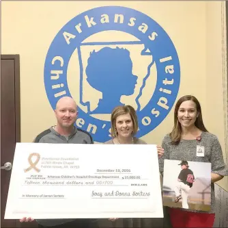  ?? COURTESY PHOTO ?? Joey and Donna Sorters of Prairie Grove present a $15,000 check to Arkansas Children’s Hospital on behalf of the Play4Jarre­n Foundation. Their son, Jarren, passed away in August 2016 of cancer. Megan Brick, right, is associate developmen­t officer for...