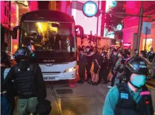  ?? — AFP file photo ?? Police detain people on a bus after they cleared protesters taking part in a rally against a new national security law in Hong Kong.