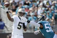  ?? PHELAN M. EBENHACK — THE ASSOCIATED PRESS ?? New Orleans Saints quarterbac­k Teddy Bridgewate­r (5) releases a pass just before he is hit by Jacksonvil­le Jaguars linebacker Najee Goode (52) during the first half on Sunday.