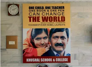  ?? Reuters ?? A poster with the pictures of Malala Yousafzai and her father Ziauddin Yousafzai hangs at the wall of Khushal School, in her home district in Swat Valley. —