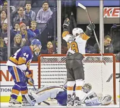  ?? AP ?? Flyers’ Claude Giroux raises stick after his OT game-winner sticks it to Islanders, who see 3-game winning streak end in disappoint­ment.