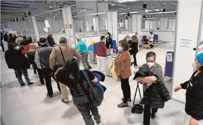  ??  ?? Desde primera hora de la mañana de ayer, decenas de personas esperaban su turno para ser vacunados en el Hospital Enfermera Isabel Zendal