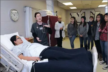  ?? NWA Democrat-Gazette/FLIP PUTTHOFF ?? Marvie Landaverde (left), nursing program student, plays the role of a patient Nov. 20 while student Leigh-Anne Pemberton talks to high school students about nursing education opportunit­ies at Northwest Technical Institute in Springdale. For more...