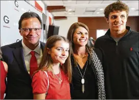  ?? CURTIS COMPTON/AJC 2018 ?? Tom Crean and his wife, Joani — the former Joani Harbaugh — son Riley and daughter Ainsley gather for a family photo in March 2018 after Crean was introduced as the new men’s basketball head coach at the University of Georgia.