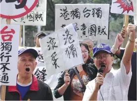  ??  ?? TAIPEI: Pro-Taiwan and China unificatio­n activists chant slogans outside a venue during a political forum hosted by Taiwan’s New Power Party (NPP) in Taipei yesterday.—AFP