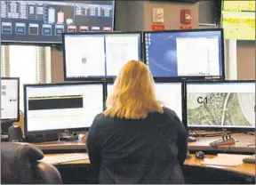 ?? LISA MARIE PANE/AP ?? A dispatcher works at a station with screens used by those who take emergency calls in Roswell, Ga. Roswell, a suburb north of Atlanta, sees between 400 and 600 calls a day.