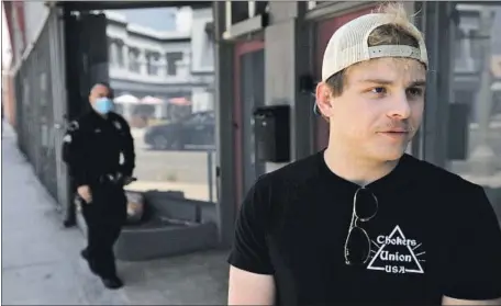  ?? Genaro Molina Los Angeles Times ?? JONATHAN LIPNICKI keeps watch along La Brea Avenue in the Fairfax district after multiple recent antisemiti­c attacks in the area.