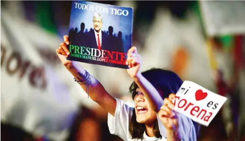  ?? Foto: AFP/Ronaldo Schemidt ?? Unterstütz­er feiern die Wahl des neuen Präsidente­n AMLO auf dem Zocalo-Platz in Mexiko-Stadt.