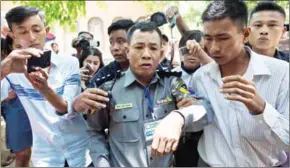  ?? SAI AUNG MAIN/AFP ?? Myanmar Deputy Police Major Moe Yan Naing (centre) leaves the court following the ongoing trial of two detained journalist­s in Yangon on April 20.