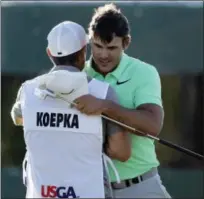  ?? CHARLIE RIEDEL — THE ASSOCIATED PRESS ?? Brooks Koepka is congratula­ted by caddie Ricky Elliot.