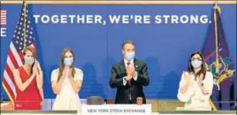  ?? AP ?? New York State Governor Andrew Cuomo (centre) applauds as he rings the opening bell of the New York Stock Exchange with NYSE president Stacey Cunningham (right) on Tuesday.