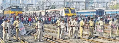  ?? VIJAYANAND GUPTA/HT PHOTO ?? Police personnel stand guard as students take to railway tracks to block train services between Matunga and Dadar stations in Mumbai on Tuesday.