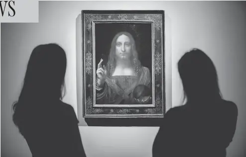  ?? TOLGA AKMEN / AFP / GETTY IMAGES ?? Christie’s employees pose in front of a painting entitled Salvator Mundi by Italian artist Leonardo da Vinci at Christie’s auction house in central London in October. It sold on Wednesday for more than US$450 million, a new record for a painting at auction.
