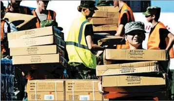  ?? CHUCK LIDDY/RALEIGH NEWS & OBSERVER ?? Boxes of tarps for victims of the storm are unloaded Tuesday in Wilmington, N.C. President Donald Trump is scheduled to visit the state on Wednesday to survey the damage.