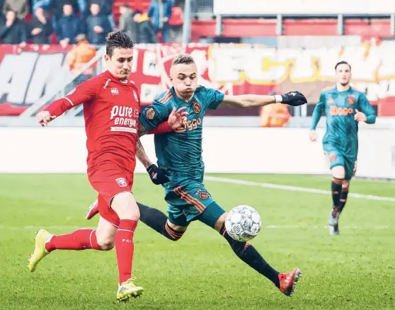  ??  ?? Ajax-spits Noa Lang (midden) in duel met Paul Verhaegh van FC Twente tijdens de eredivisie­wedstrijd in Enschede. Ajax won met 5-2, Lang scoorde driemaal.