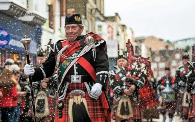  ??  ?? The City of Rochester Pipe Band leads the Dickensian parade along the High Street, which is lined with cheering and waving spectators.