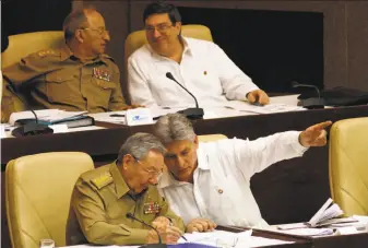  ?? Ismael Francisco / Associated Press 2013 ?? Cuban President Raul Castro (left) confers with Vice President Miguel Diaz-Canel during the opening of a legislativ­e session at Cuba’s National Assembly in Havana in 2013.