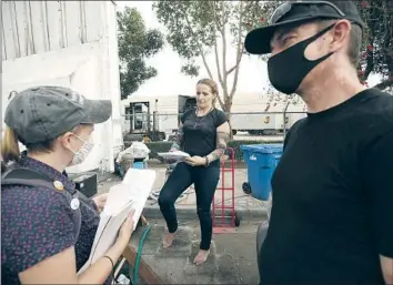  ?? Photograph­s by Al Seib Los Angeles Times ?? ZACK GUSTINE, right, and Chelsea L. Shover of UCLA, left, encourage Kimberly Conti to get vaccinated. Gustine, who is unhoused, was himself vaccinated earlier that day and recruited as a peer ambassador.