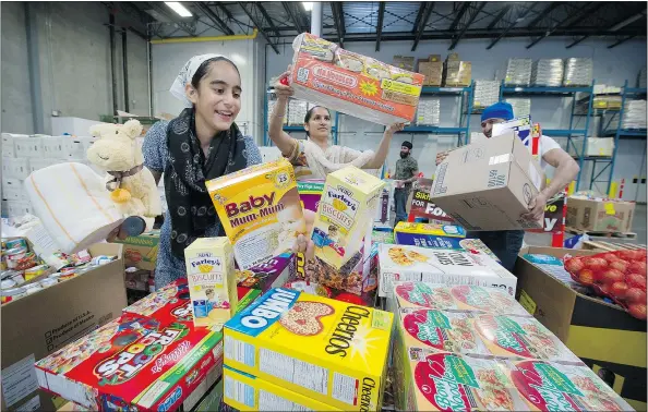  ?? MARK VAN MANE/PNG ?? Members of the Metro Vancouver Sikh community sort food and supplies collected for Fort McMurray fire victims inside the Fruiticana warehouse in Surrey Sunday. The items will be transporte­d to Edmonton and distribute­d to families displaced by the fire.