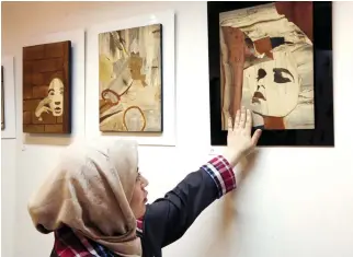  ??  ?? Iranian victims of acid attacks present their work at the Ashianeh gallery in Tehran on Wednesday to raise awareness and money. (AFP)