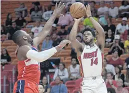  ?? MICHAEL LAUGHLIN/STAFF PHOTOGRAPH­ER ?? Heat point guard Derrick Walton Jr. shoots over the Washington Wizards’ John Wall during Wednesday’s game.